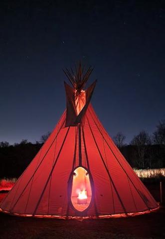 The tipi tent at night when the fire is going. 
